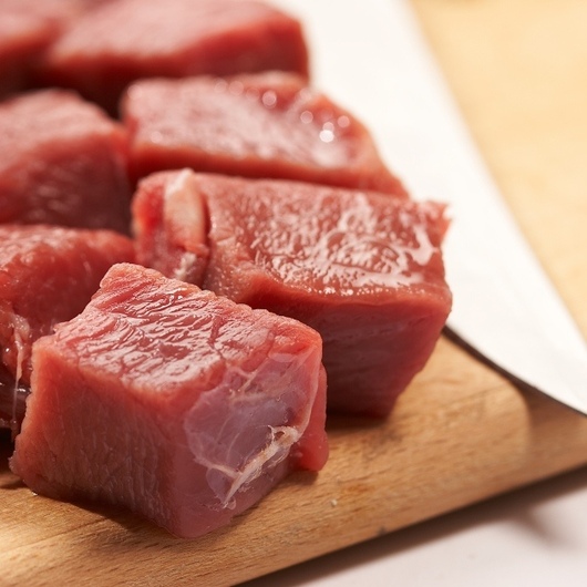 shards of meat with kitchen knife on the wood board